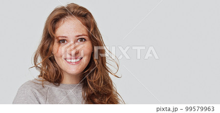 Indoor shot of cute redhead woman with long ginger hairstyle. Young female smiling  99579963