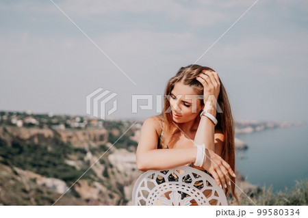 Happy boho woman portrait. Boho chic fashion style. Outdoor photo of free happy woman with long hair, sunny weather outdoors with sea mountains nature beautiful background. 99580334