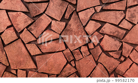 暗い薄赤茶色の乱張りした乱形の石材の表面の背景画像 99582170