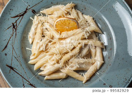 Italian pasta sprinkled with cheese in a plate with streaks of sauce 99582929