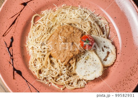 Italian pasta sprinkled with cheese in a plate with streaks of sauce Italian pasta sprinkled with cheese in a plate with streaks of sauce 99582931