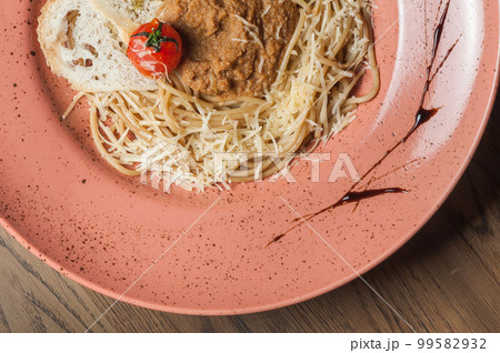 Italian pasta sprinkled with cheese in a plate with streaks of sauce 99582932