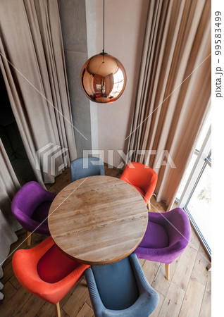 A place to relax in a cafe. A round table and soft chairs around it 99583499