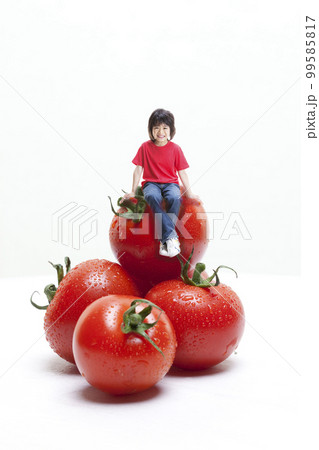 とまと大好き！トマトボーイ 巨大トマトに座る少年（合成） 99585817