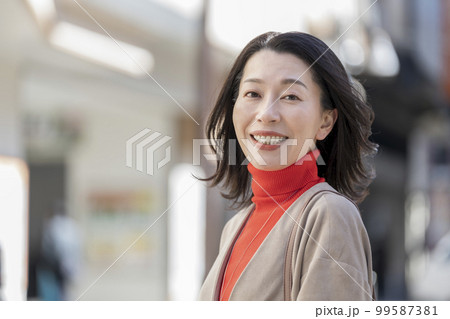 カメラ目線で笑顔の40代後半の女性 99587381