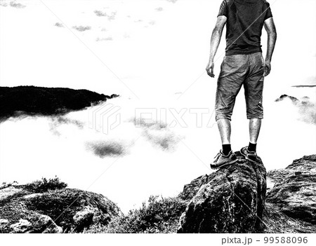 Person on a top of mountains in a misty cloud. Sunrise view. Tourist enjoy moment 99588096