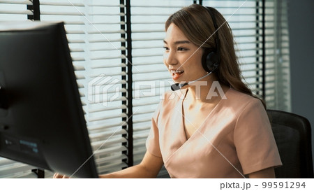 Competent female operator working on computer and while talking with clients. 99591294