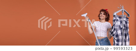 Panoramic frame of young girl. A smile on your face. A steamer for ironing. A girl with curly hair. 99593323