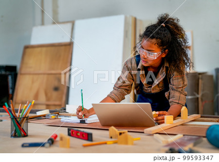 Smart Asian carpenter woman but African hair style record detail of wood product on paper 99593347
