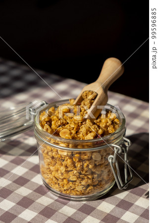 Homemade granola with nuts and seeds in eco glass jar. Healthy snack on breakfast. Muesli from oatmeal, raisins, honey, cranberry, flax, almond, cashew, freshly baked Homemade granola with nuts and seeds in eco glass jar. Healthy snack on breakfast. Muesli from oatmeal, raisins, honey, cranberry, flax, almond, cashew, freshly baked 99596885