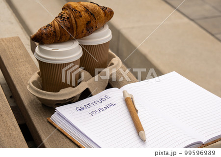 Writing Gratitude Journal on wooden bench. Coffee and croissants morning routine. Today I am grateful for. Self discovery journal, self reflection creative writing, self growth personal development Writing Gratitude Journal on wooden bench. Coffee and croissants morning routine. Today I am grateful for. Self discovery journal, self reflection creative writing, self growth personal development 99596989
