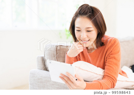 タブレットを見る女性　笑顔 99598643