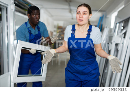 Portrait of man and woman worker who are conflicting with window frames 99599338