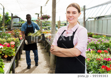 Florist woman posing in glasshouse 99599363
