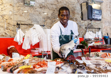 Salesman offering fresh fish Salesman offering fresh fish 99599463