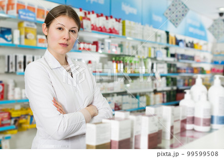 pharmacist standing with arms crossed in pharmacy pharmacist standing with arms crossed in pharmacy 99599508