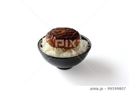 茶碗に盛ったご飯の上にのったハンバーグ 99599807