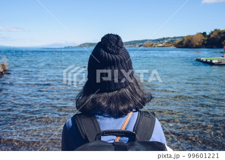 Back view of Asian girl traveling in Taupo with the scenery view of Lake Taupo the largest fresh water lake in New Zealand. Back view of Asian girl traveling in Taupo with the scenery view of Lake Taupo the largest fresh water lake in New Zealand. 99601221