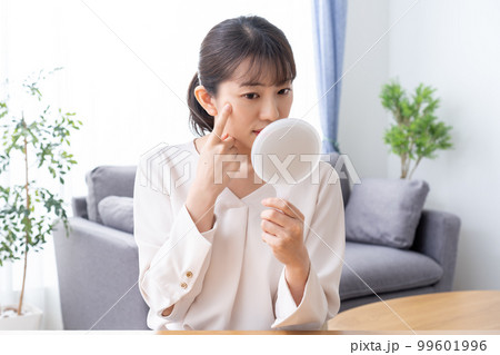 手鏡で肌トラブルを確認する女性 99601996