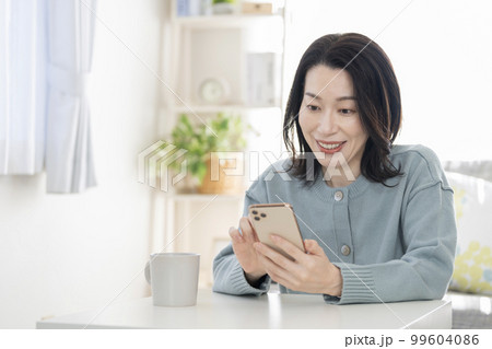 スマートフォンを操作するアラフィフの女性 スマートフォンを操作するアラフィフの女性 99604086
