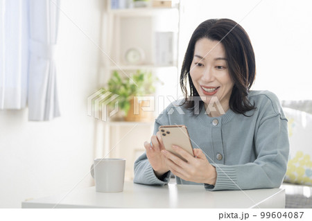 スマートフォンを操作する40代の女性 99604087