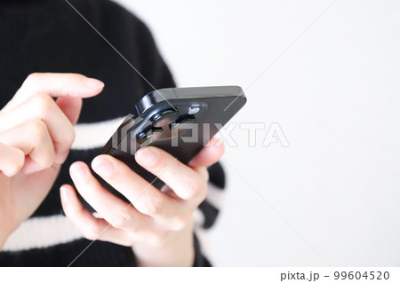 スマホを操作する手元 99604520