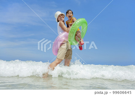 夏の海で遊ぶ娘と母親 99606645