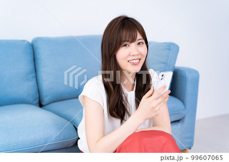 明るいリビングでスマホを使う若い女性 明るいリビングでスマホを使う若い女性 99607065