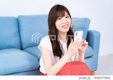 明るいリビングでスマホを使う若い女性 明るいリビングでスマホを使う若い女性 99607066