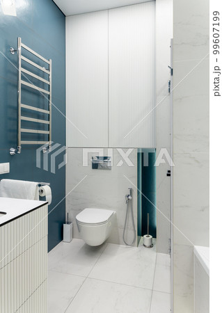 Blue and white bathroom with toilet, big mirror, shower cabin, lighting and countertop basin. Blue and white bathroom with toilet, big mirror, shower cabin, lighting and countertop basin. 99607199