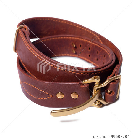 A rolled-up brown leather belt with a metal buckle on a white background is isolated. 99607204