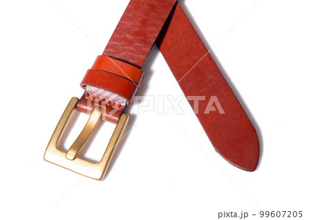 A crossed brown leather belt with a metal buckle on a white background is isolated. A crossed brown leather belt with a metal buckle on a white background is isolated. 99607205