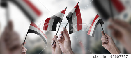 A group of people holding small flags of the Yemen in their hands 99607757