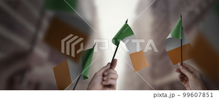 A group of people holding small flags of the Ireland in their hands 99607851