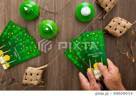 Hand holding Money envelop for muslim Eid celebration Hand holding Money envelop for muslim Eid celebration 99609054