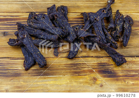 Slices of biltong (South African dried meat) on wooden table Slices of biltong (South African dried meat) on wooden table 99610278