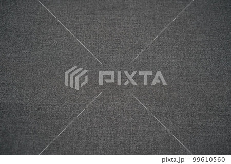 Grey textured fabric for graphic and web design backgrounds, texture of a plain grey twill weave textile material. Selective horizontal focus. Copy space. 99610560
