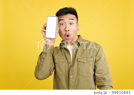 Surprised chinese man holding a mobile with a blank screen Surprised chinese man holding a mobile with a blank screen 99610883