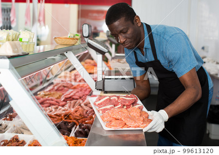 Butcher working behind counter 99613120