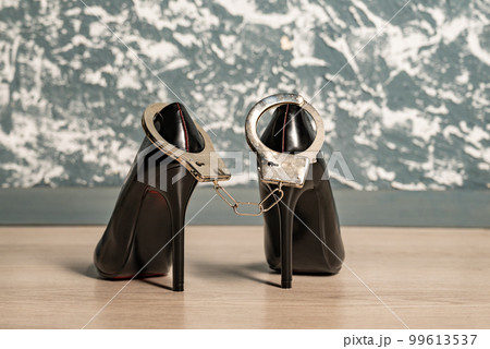 Adult sex games. Kinky lifestyle. Pair of black high-heeled shoes and handcuffs. Bdsm outfit 99613537