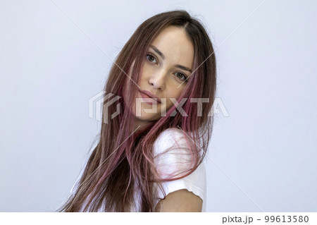 Portrait of a young woman in white with pink hair, head near shoulder. Girl on white background. 99613580