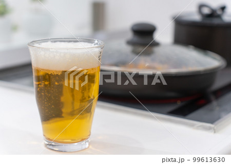 キッチンで料理をしながらビールを飲む 99613630