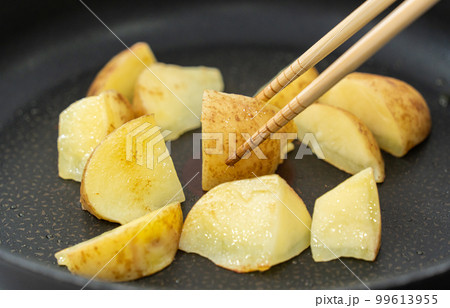 フライパンでじゃがいもを炒める フライパンでじゃがいもを炒める 99613955