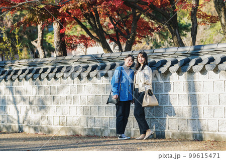 秋に友達と旅行へ出かける女性 99615471