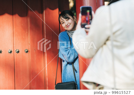 旅先で写真を撮る女性 99615527