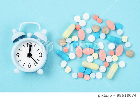 Medicine time. High angle view of colorful medicines and pills on alarm clock. 99618074