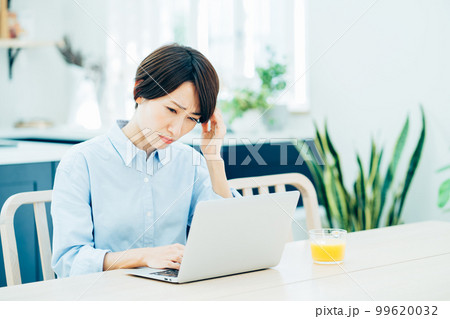 リビングでテレワークをするミドル女性。 99620032