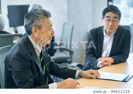 オフィスで打ち合わせするスーツ姿のシニアビジネスマン 99622239