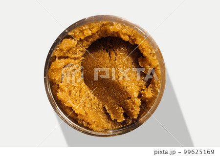 Texture of an organic scrub with salt and natural oils in a round jar 99625169