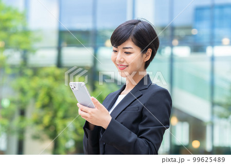 スマホを持つビジネスウーマン　撮影協力「LINK FOREST」 99625489